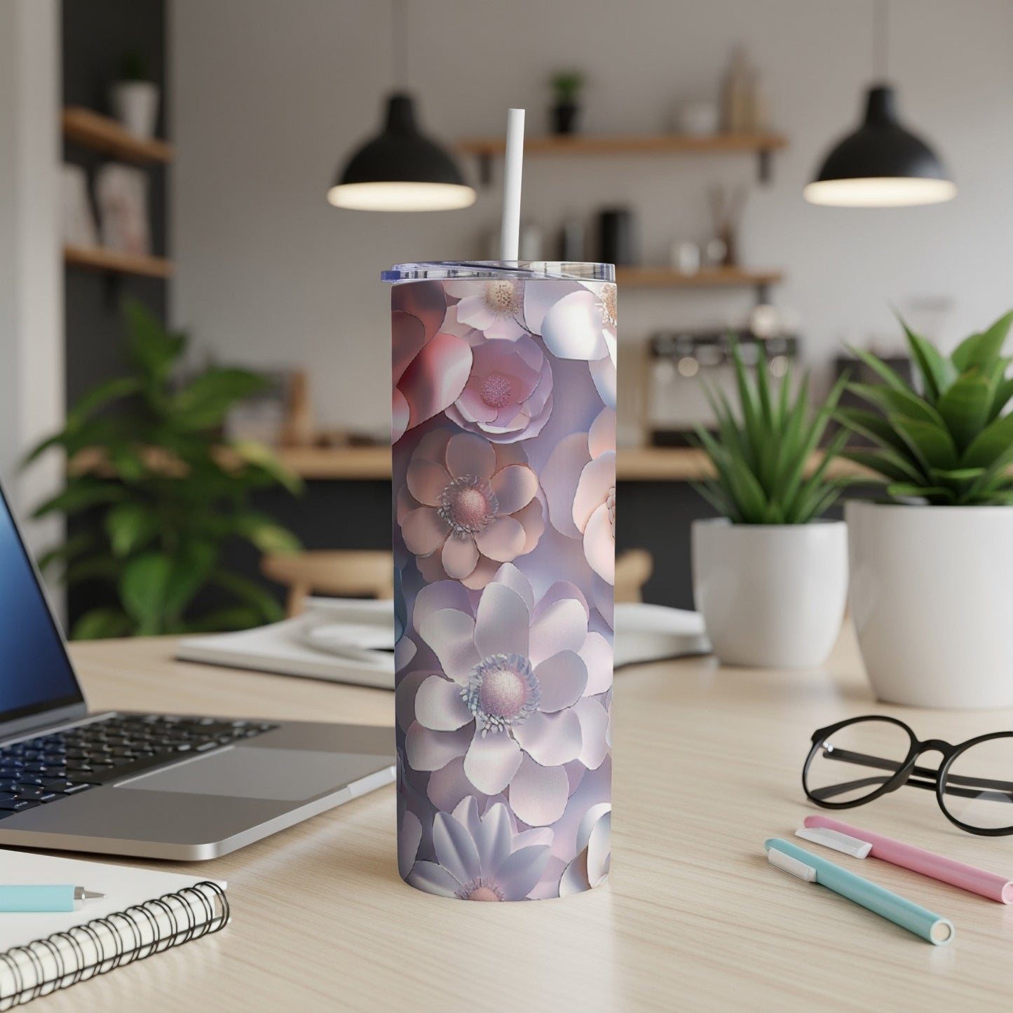 Floral patterned tumbler with white straw on desk.