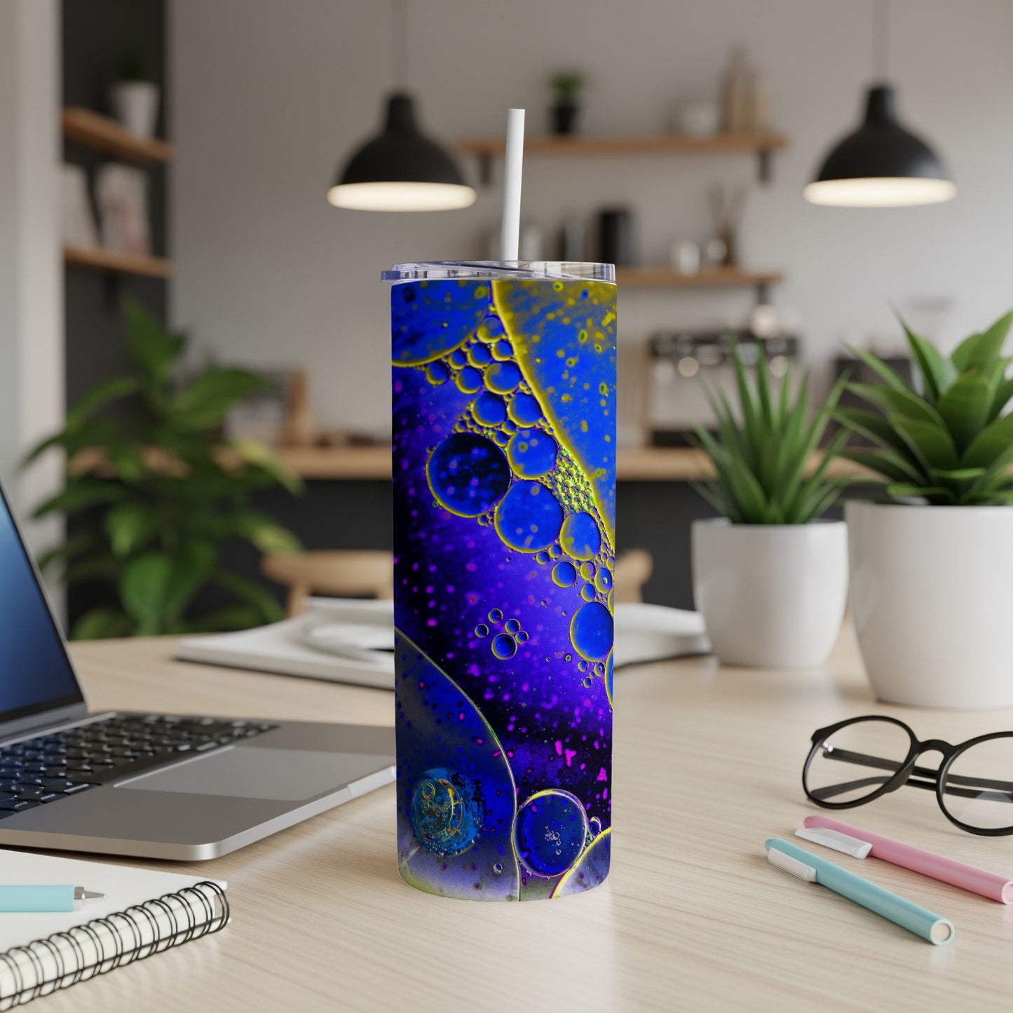 Purple tumbler with abstract oil and water pattern and a straw.