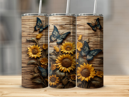 Three tumblers decorated with sunflowers and blue butterflies on a wood grain background.