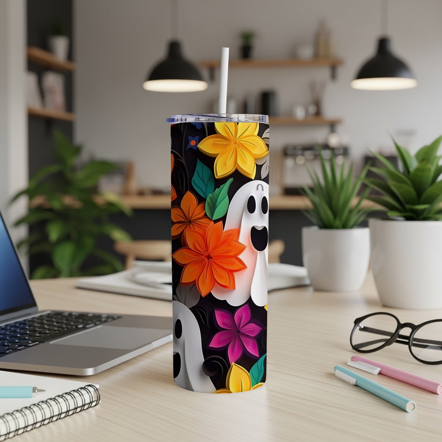Tumbler with ghosts and colorful flowers on a black background.