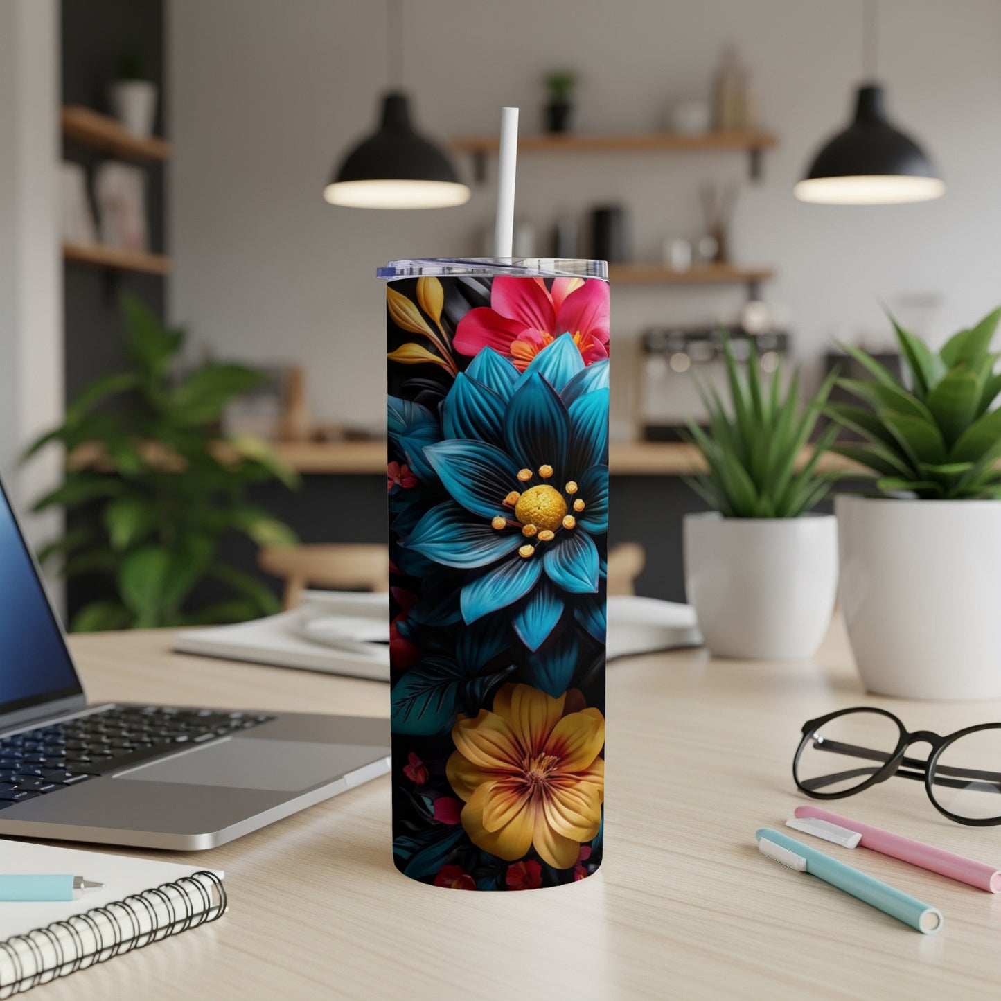 Tumbler with blue, yellow, and pink floral design on a desk.