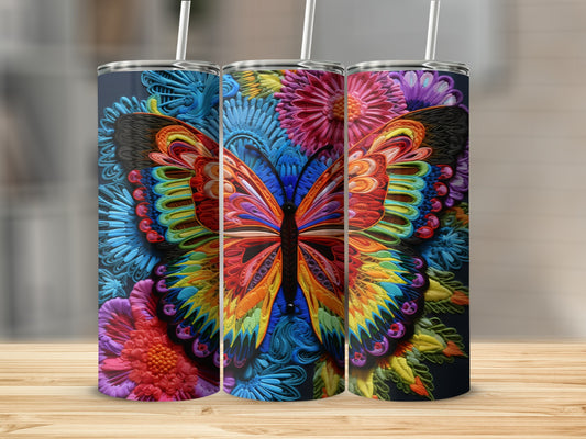 Three tumblers with colorful butterfly and floral designs on a wooden surface.