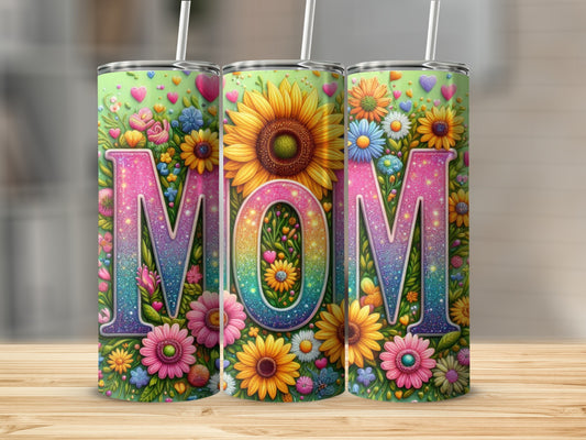 Three tumblers with "MOM" in colorful floral letters and glitter.