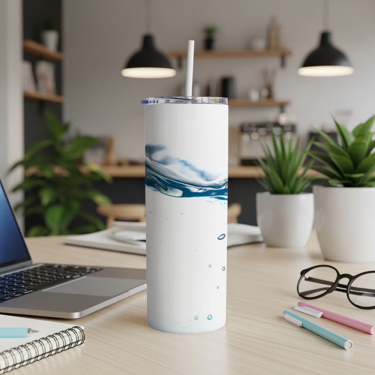White tumbler with a blue water splash design and straw.
