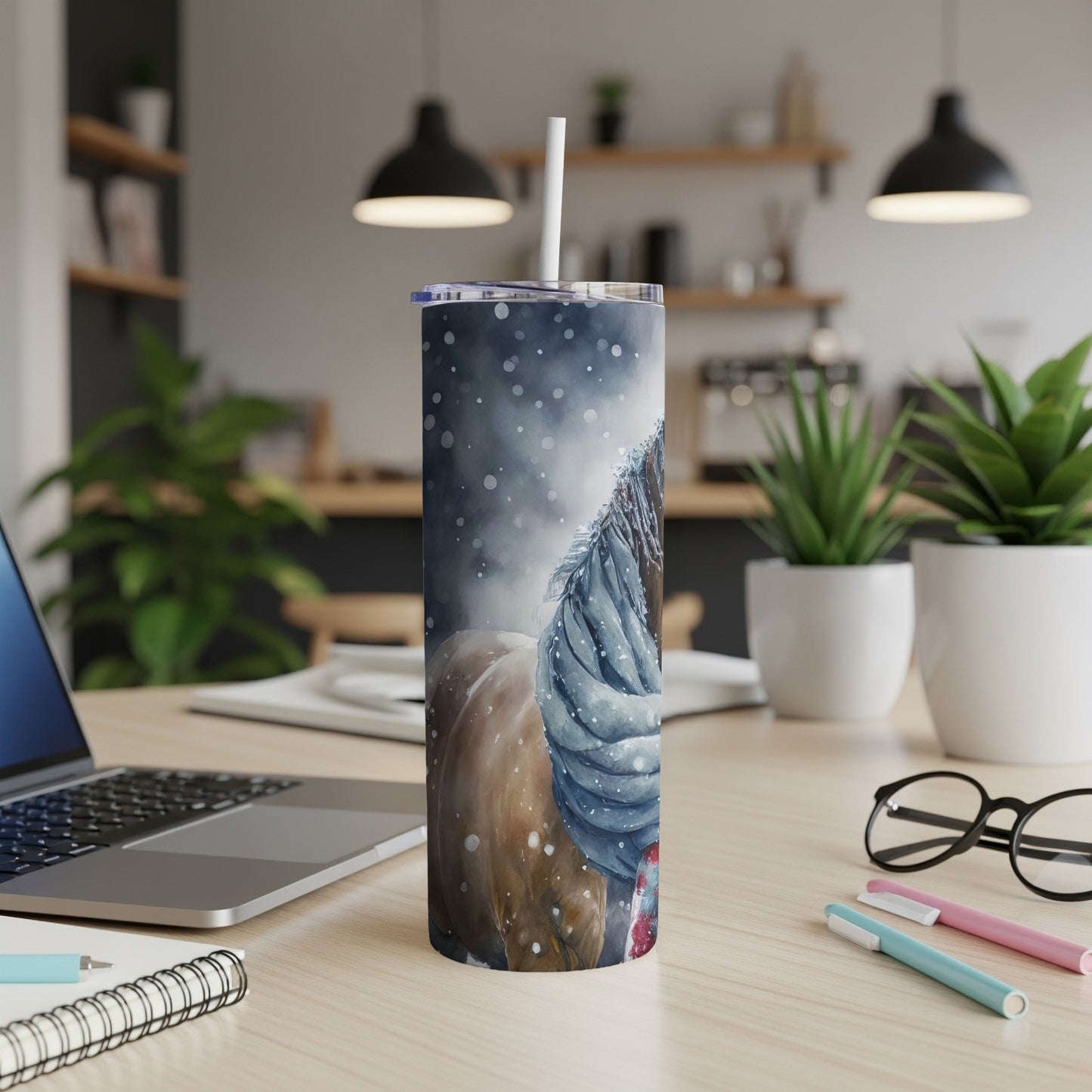 Horse in scarf on a snowy tumbler on a desk.
