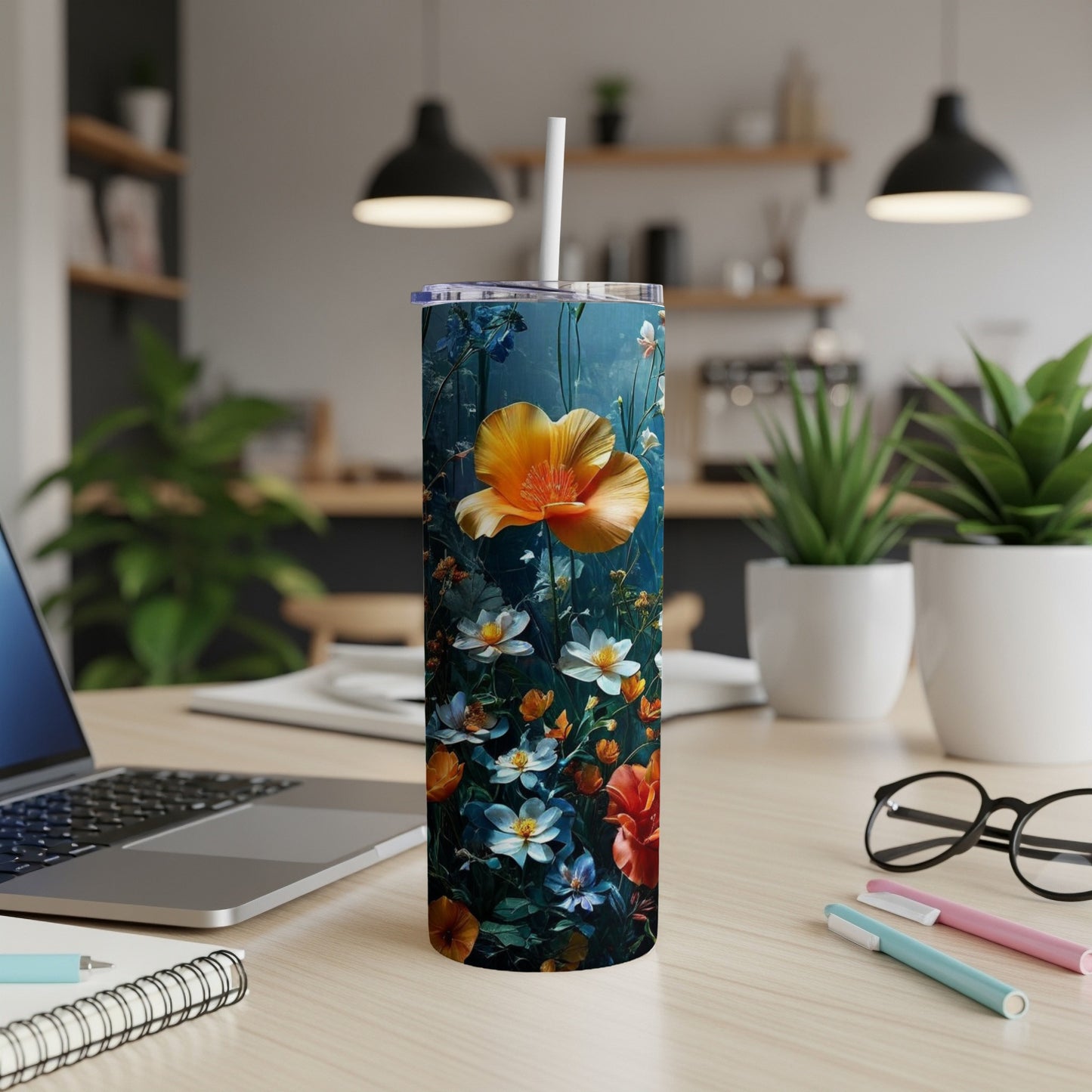 Floral pattern tumbler with a large orange poppy on a desk.