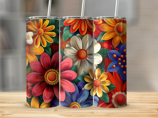 Three colorful floral tumblers with straws on a wooden surface.