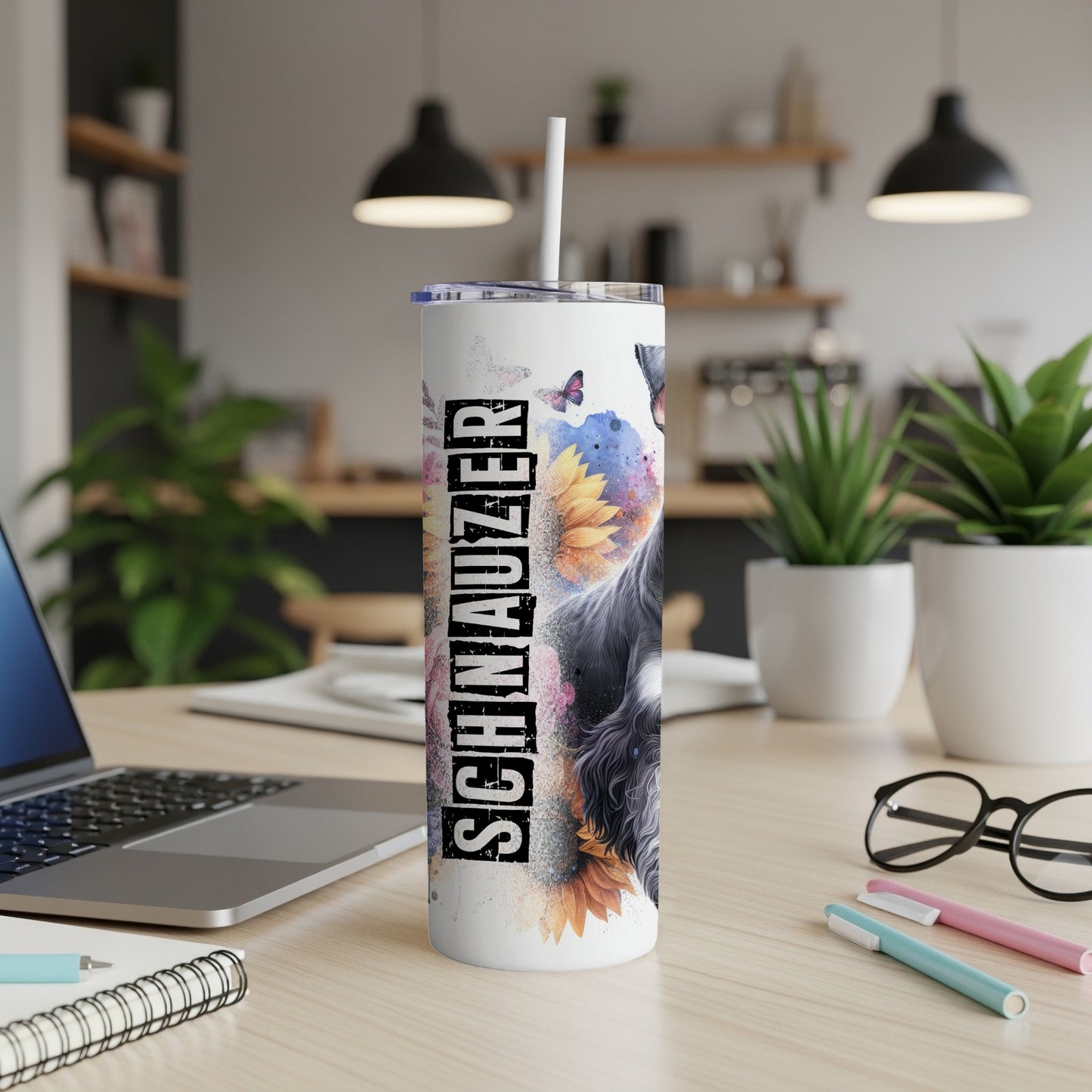 Schnauzer tumbler with floral and butterfly accents, on a desk.