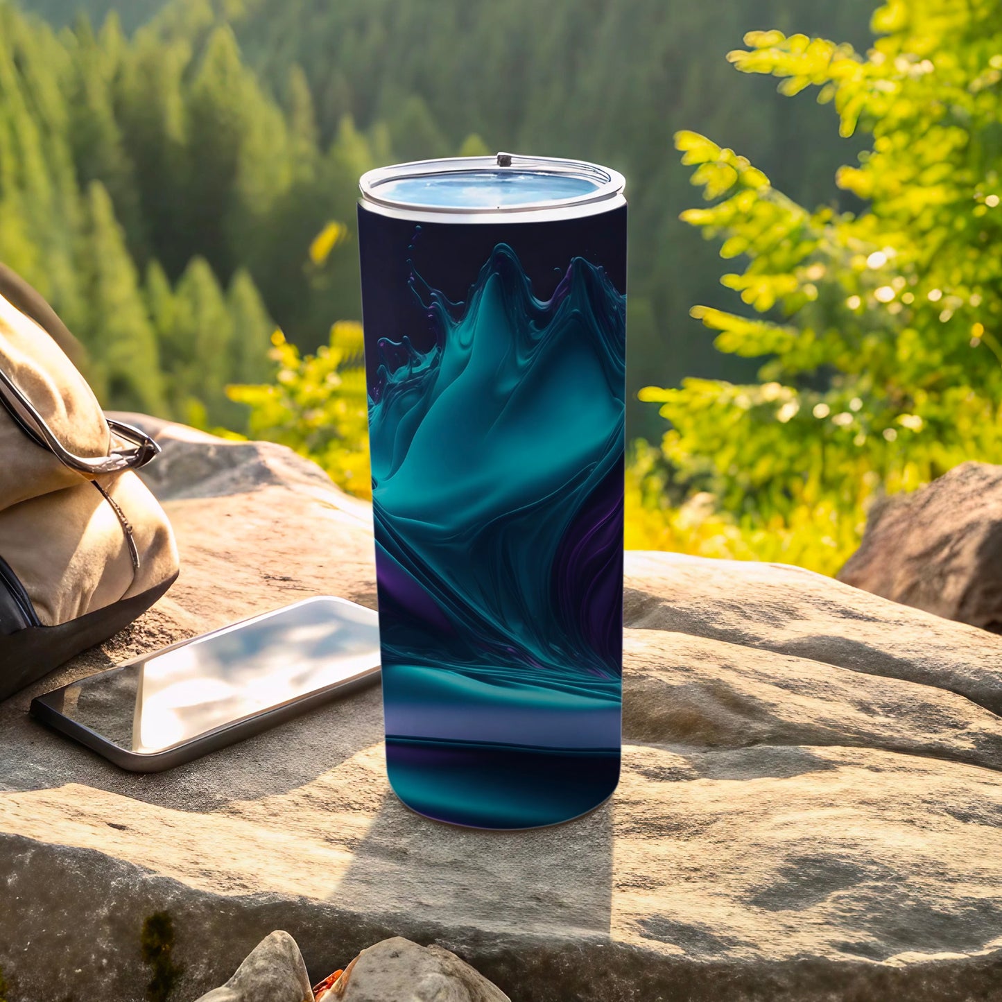 Blue and purple abstract design on a tumbler, resting on a rock.
