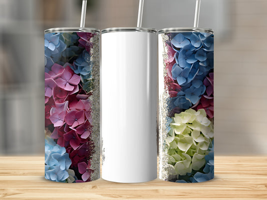 Three tumblers with floral designs and glitter accents on a wooden surface.