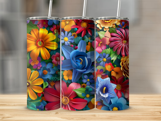 Three floral tumblers with colorful flowers and straws on a wooden surface.