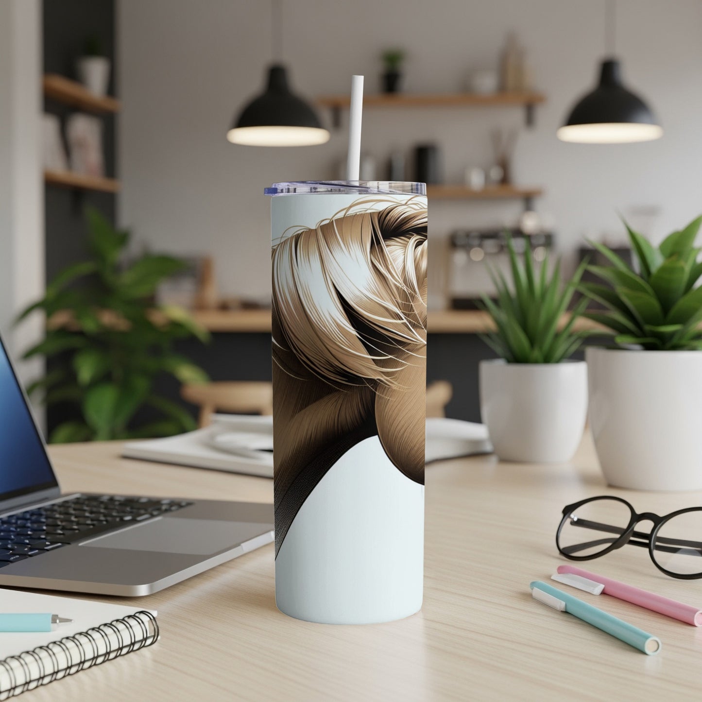 White tumbler with a close-up illustration of blonde hair on a desk.