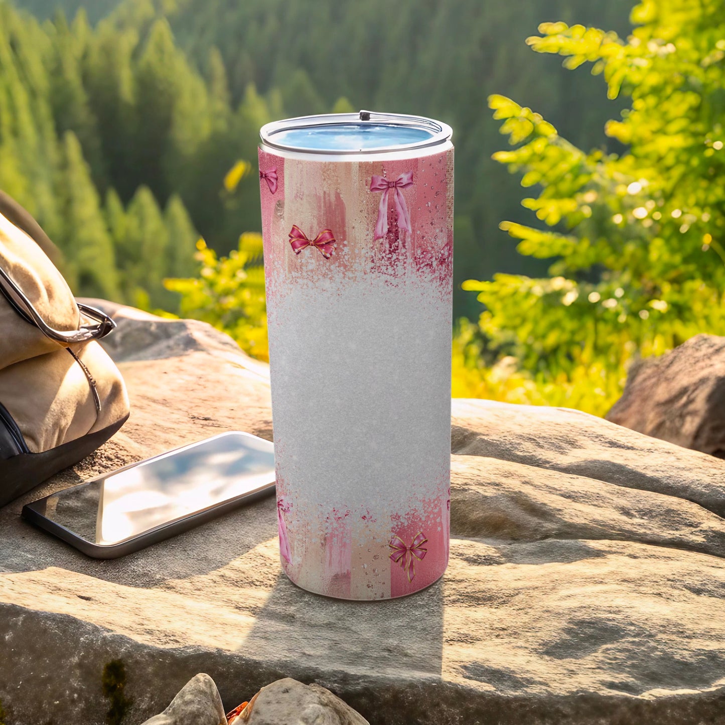 Pink ribbon and ballet slipper patterned tumbler on a rocky outcrop.