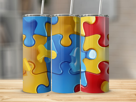 Three colorful puzzle piece tumblers on a wooden surface.
