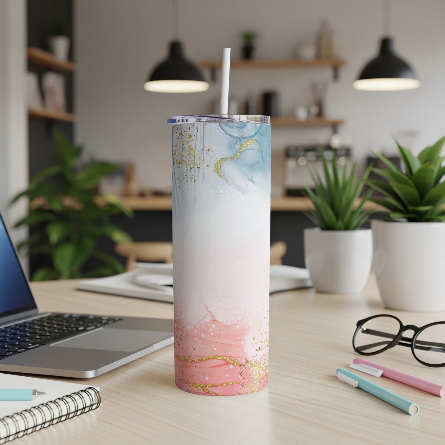 Tall tumbler with pink, blue, and gold marble design, on a desk.