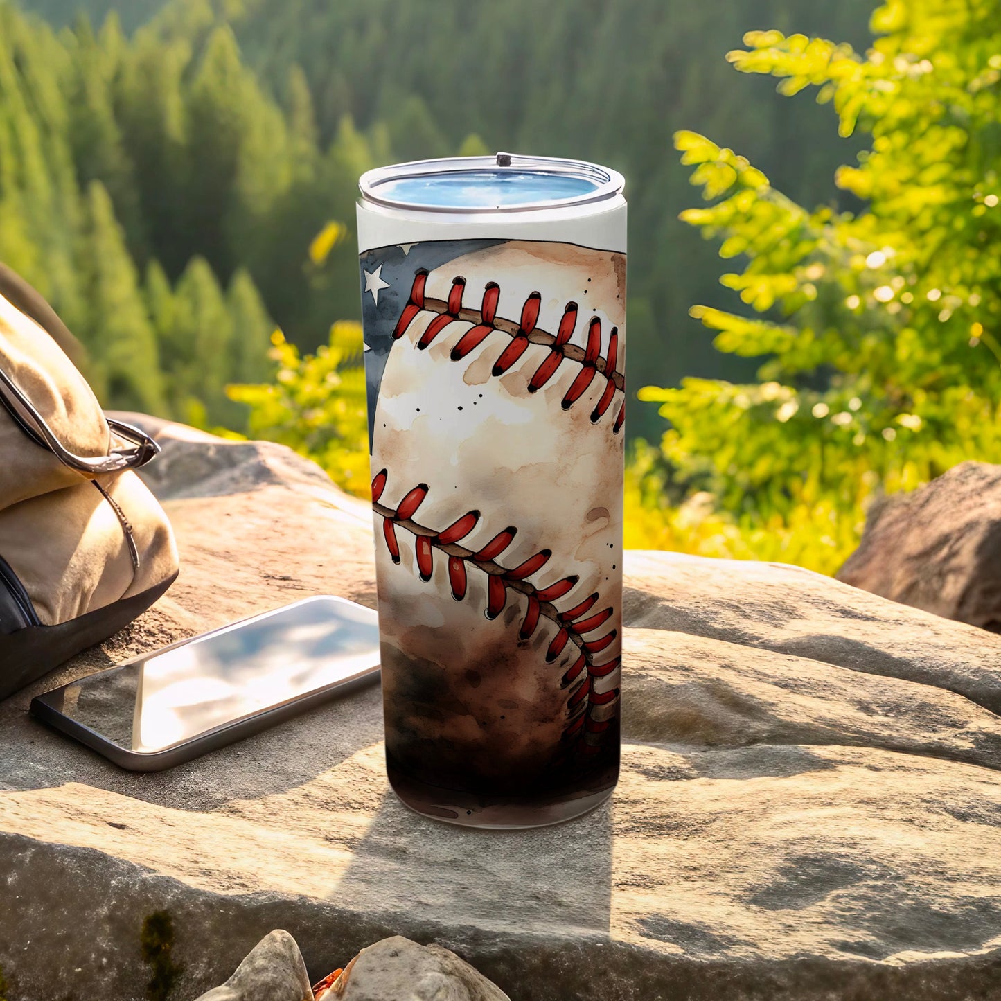 Baseball tumbler with American flag design on rocky outcrop near backpack.