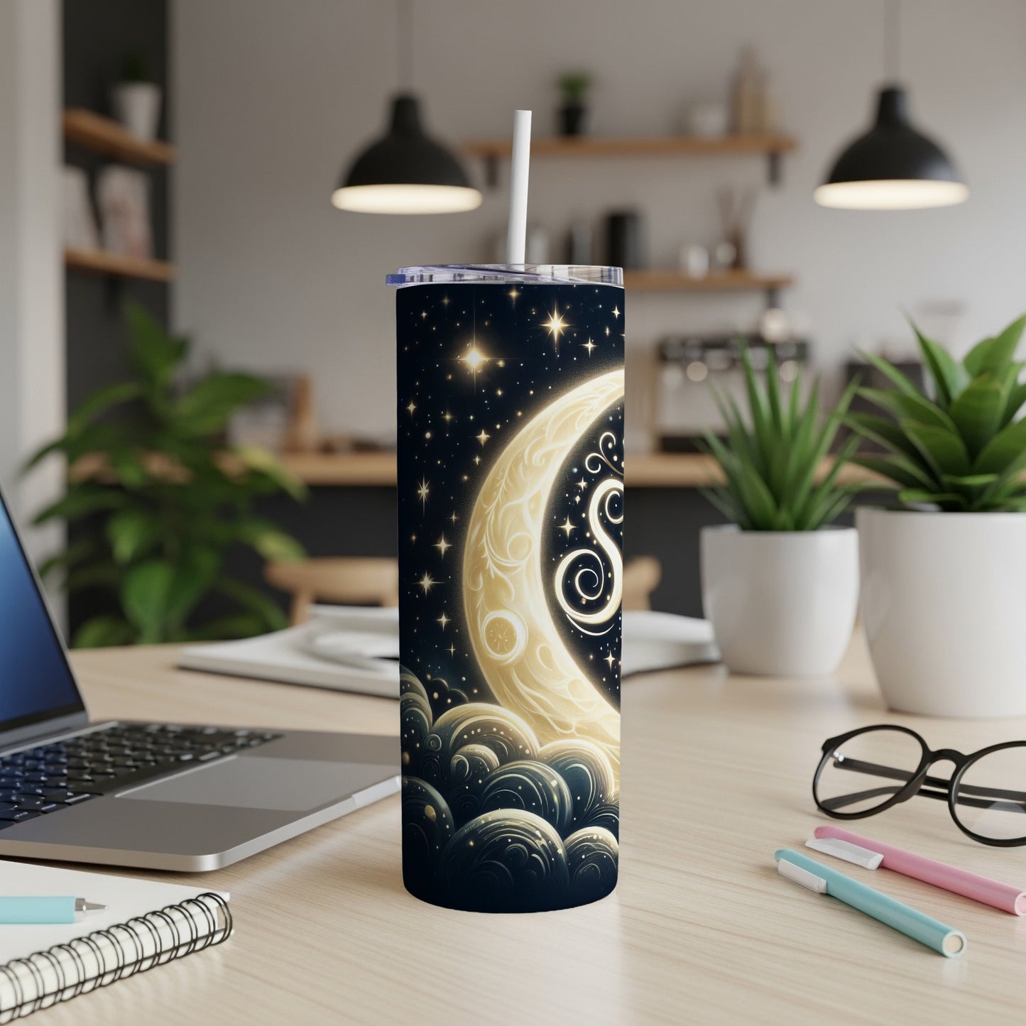 Moon and star celestial design tumbler with straw on a desk.