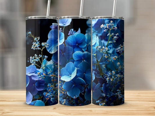 Three tumblers adorned with vibrant blue hydrangea flowers and greenery.