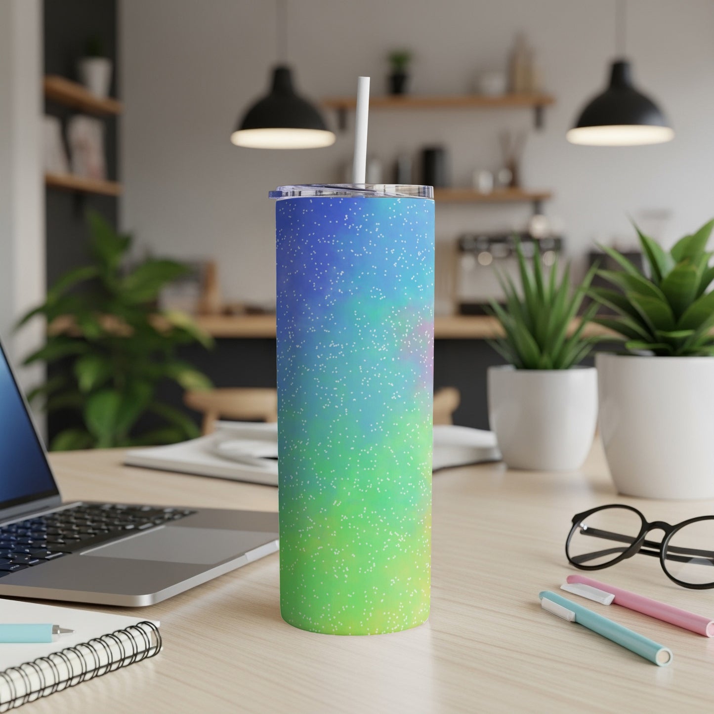Gradient tumbler with white dots and a straw in a home office setting.