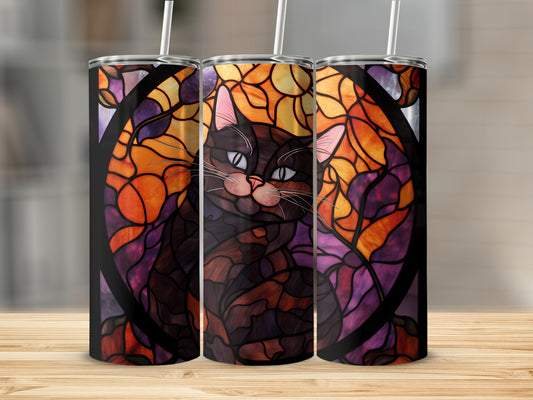 Stained glass cat tumbler with straw on a wooden surface.