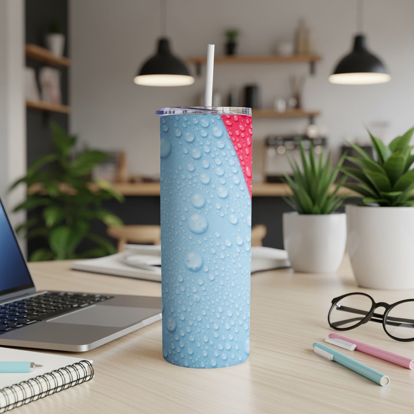 Blue tumbler with water droplet design and pink top.
