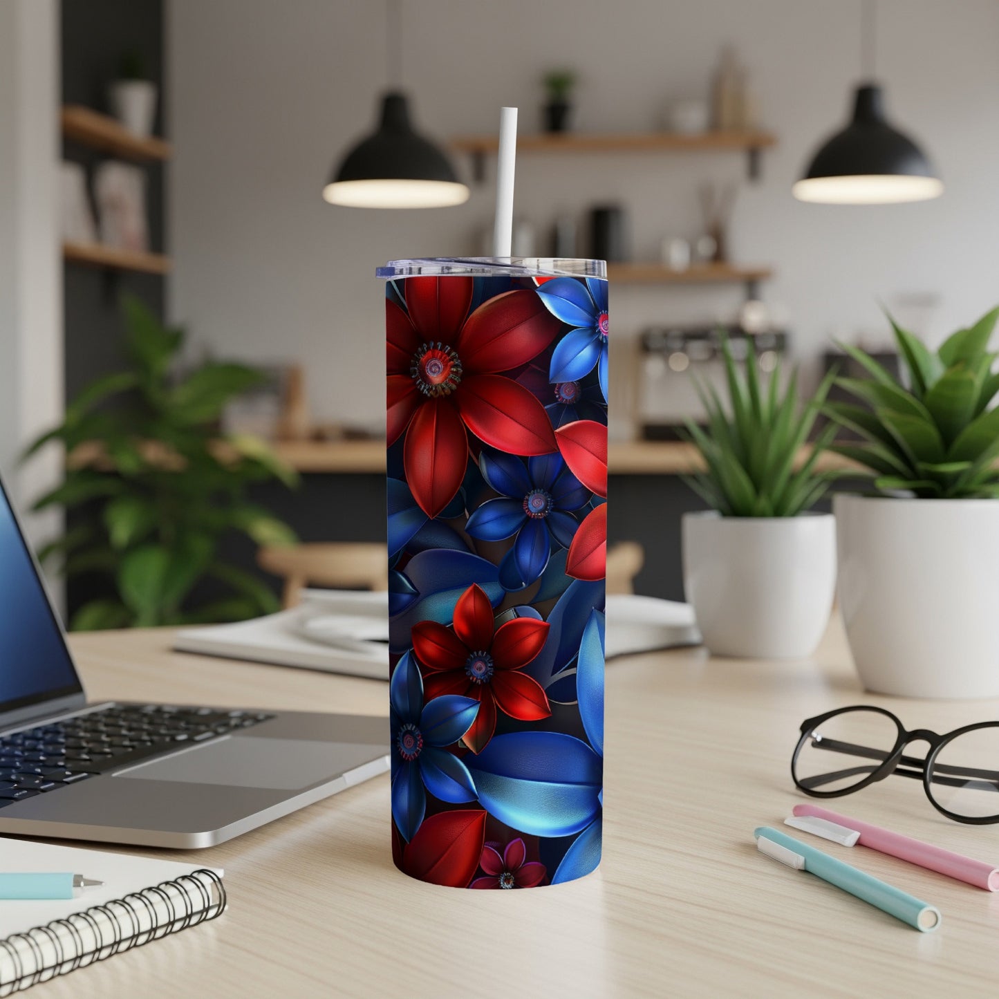 Red and blue floral pattern on a stainless steel tumbler with a straw.