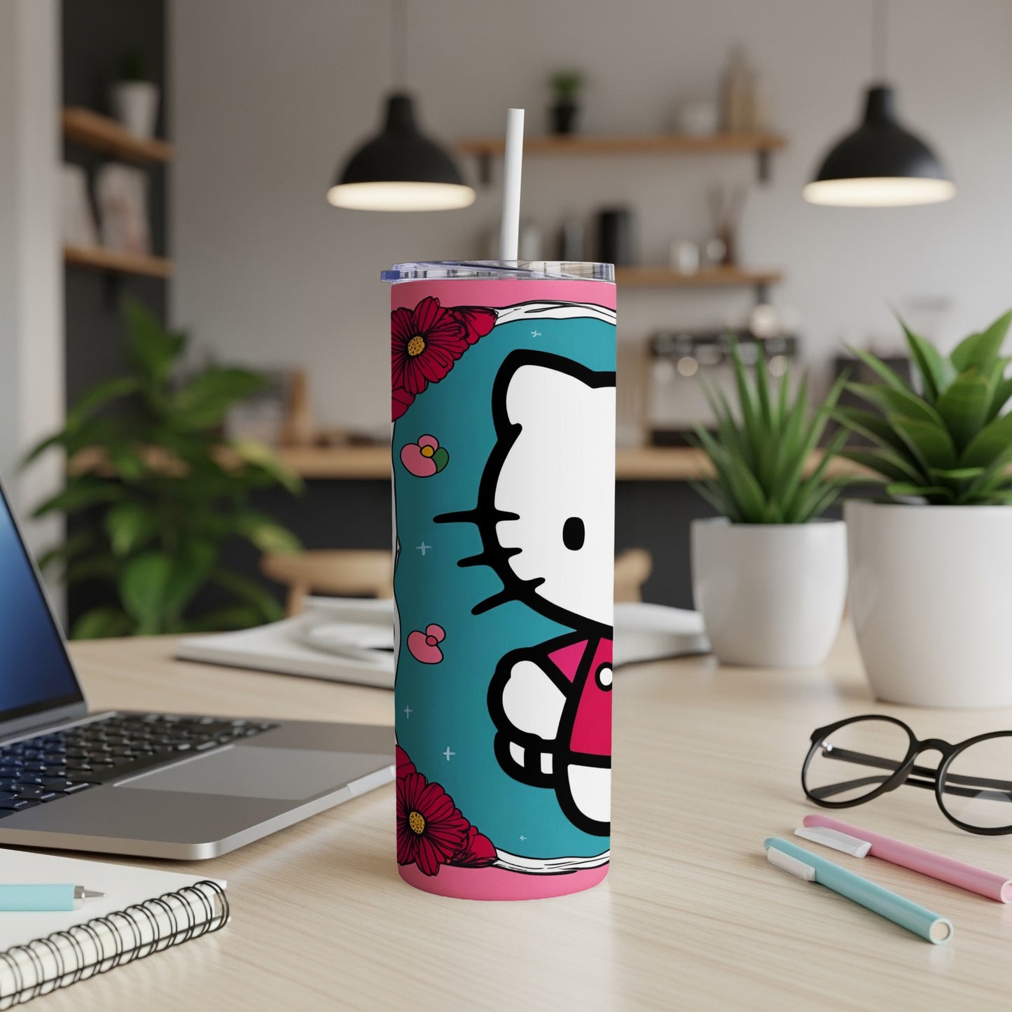 Hello Kitty tumbler with flowers and a straw on a desk.