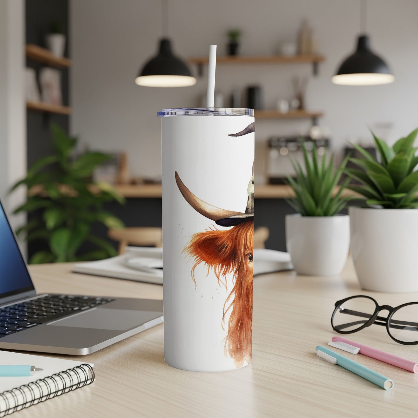 White tumbler with highland cow watercolor art and straw.