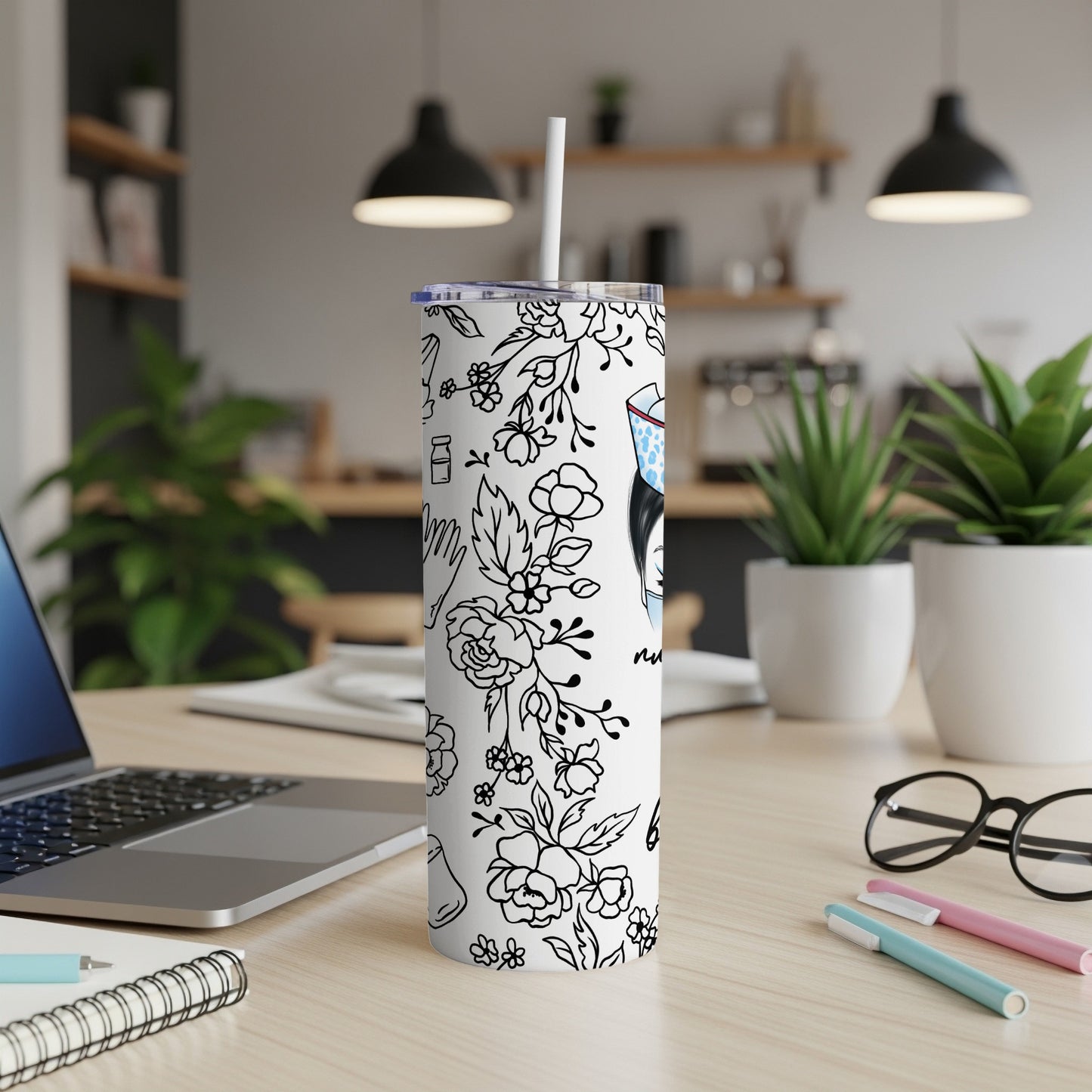 White tumbler with floral and medical line art patterns, straw inserted.