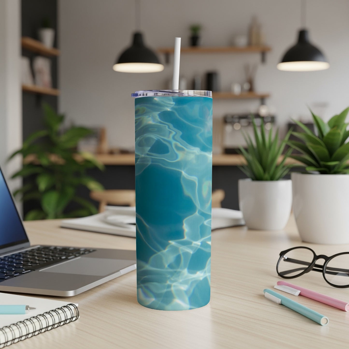 Blue water ripple pattern on a tumbler with straw on a desk.