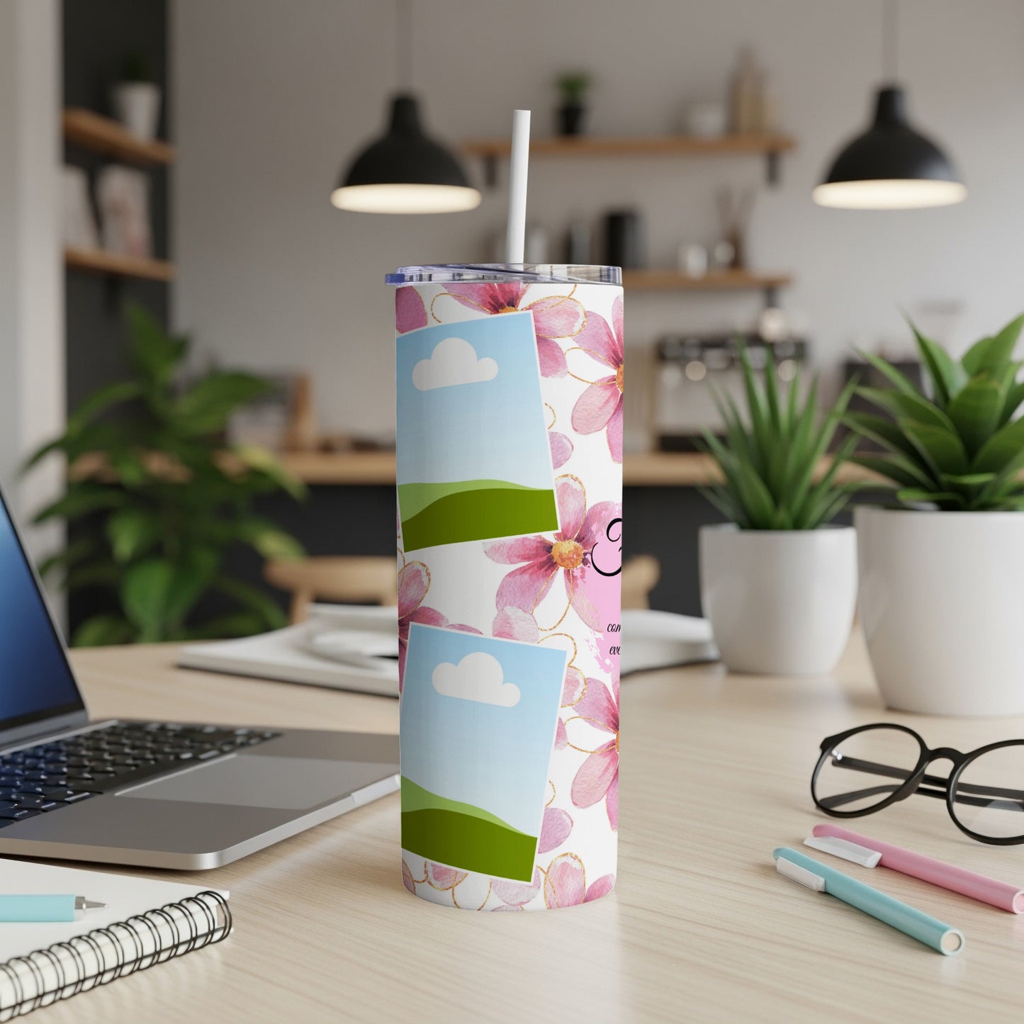 Tumbler with pink flowers, photo placeholders, and a straw on a desk.