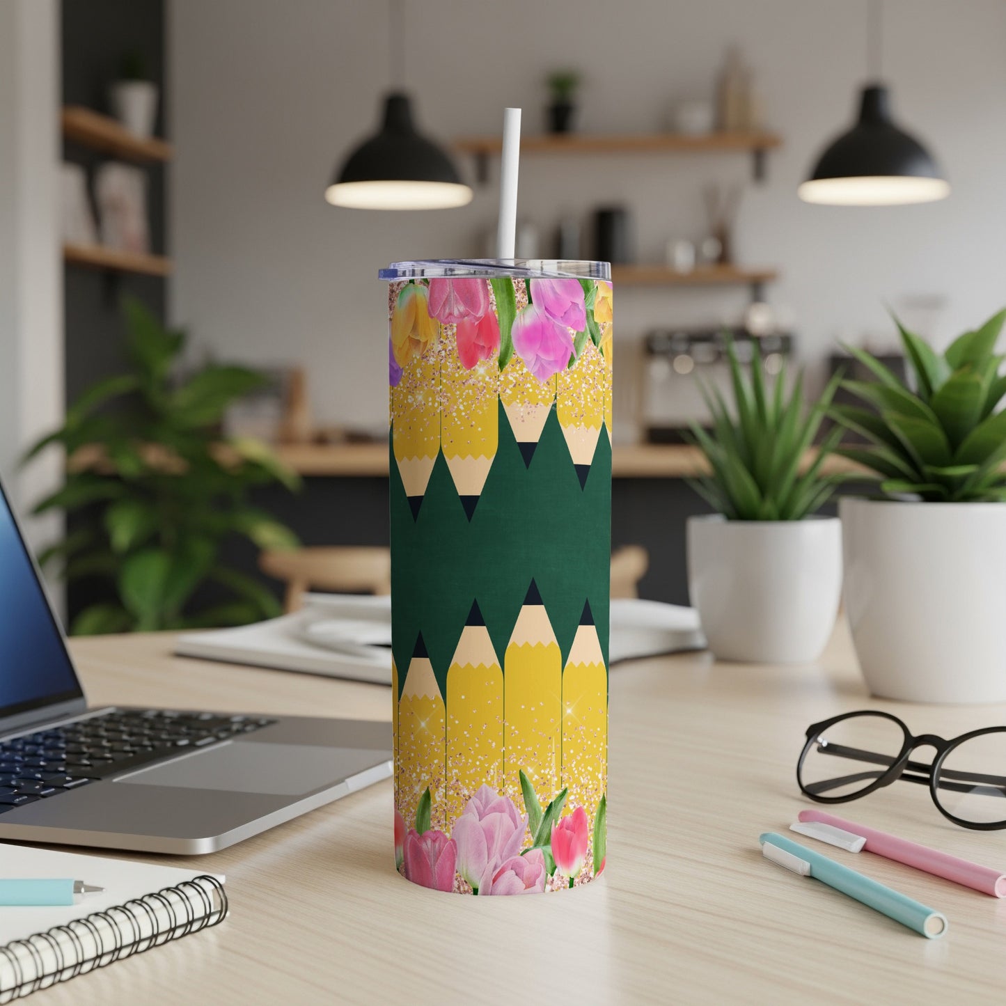 Green tumbler with a pattern of yellow pencils and pink flowers.