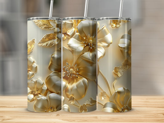 Three gold floral tumblers with straws on a wooden surface.