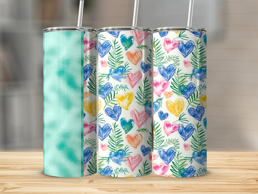 Three tall tumblers with different colorful patterns, one with green texture.