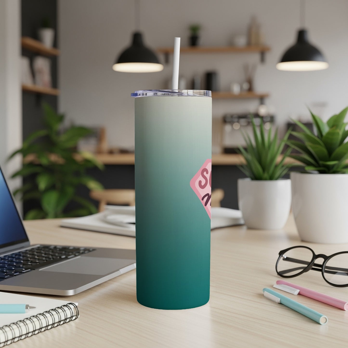 Gradient tumbler with "SIS" text in pink heart on desk next to laptop.