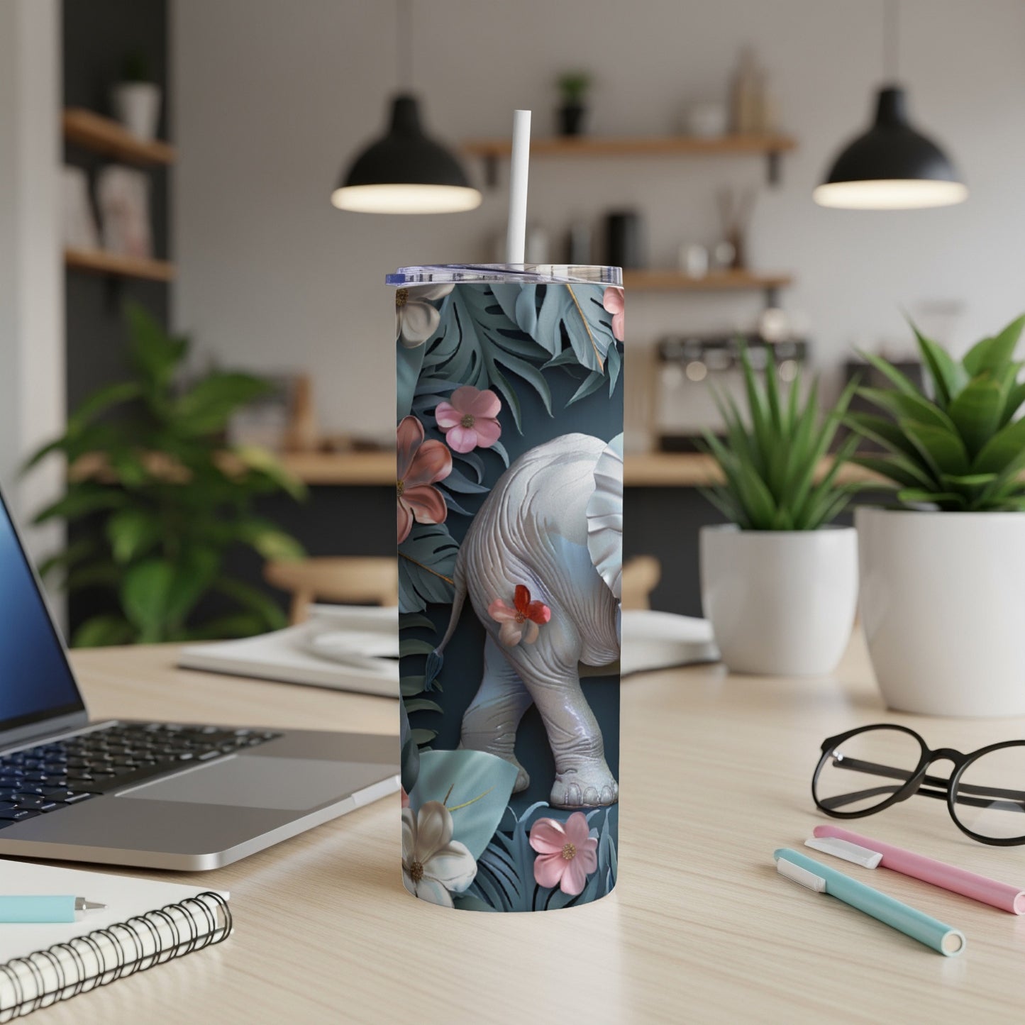 White elephant and floral design on a dark blue background, on a tumbler.