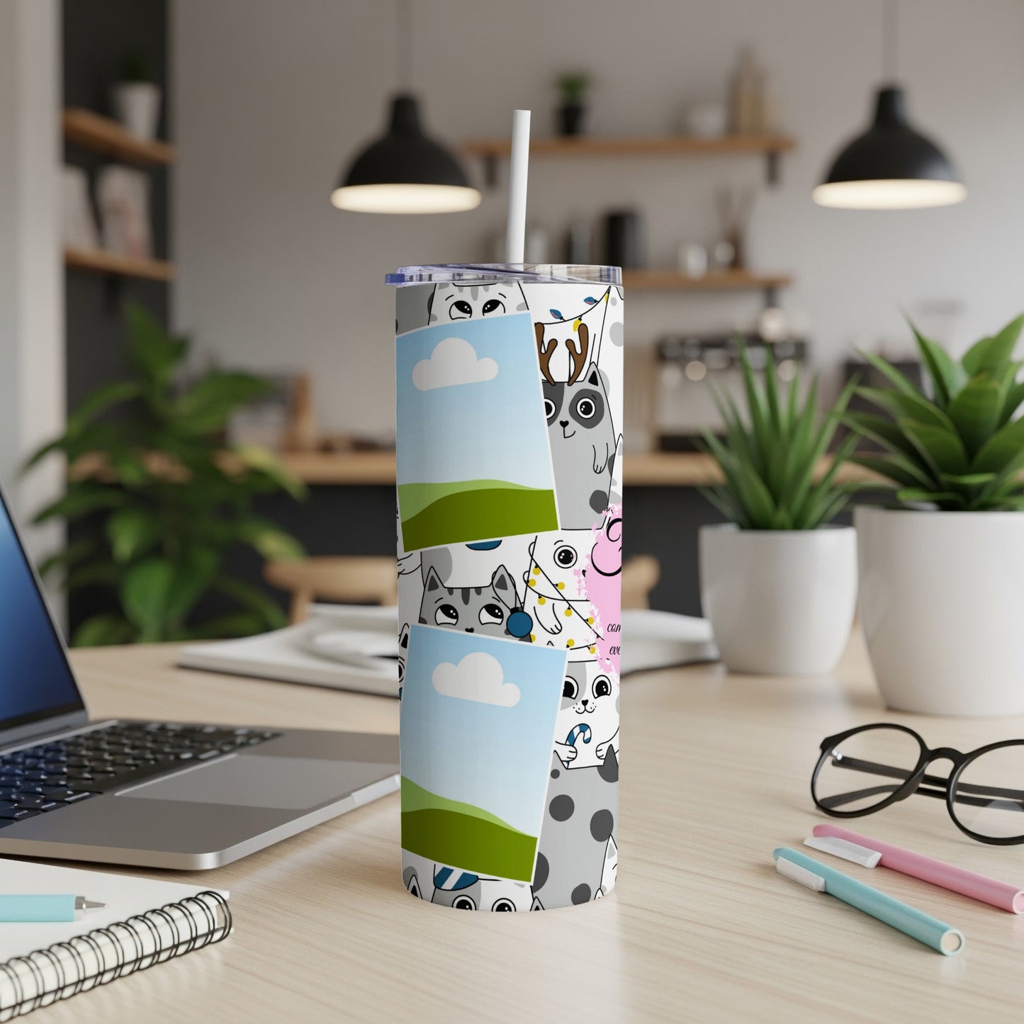 Tumbler with cartoon cat pattern and attached photo frames on a desk.