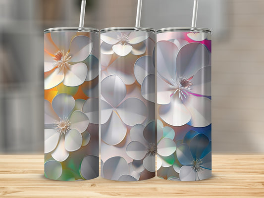 Three tumblers with white floral patterns on a wooden surface.