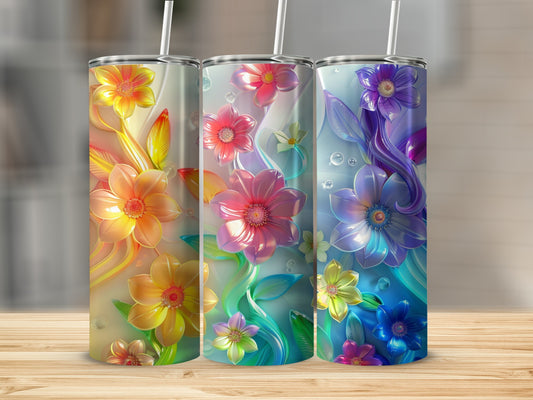 Three tumblers with colorful floral designs on a wooden surface.