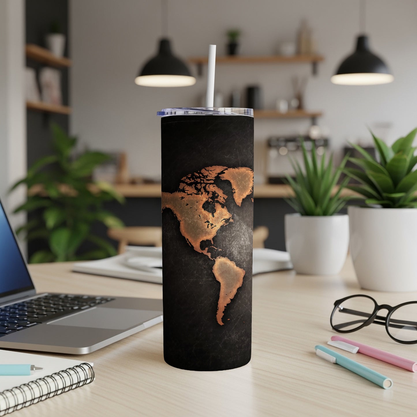 Black tumbler with copper map of North and South America and a white straw.