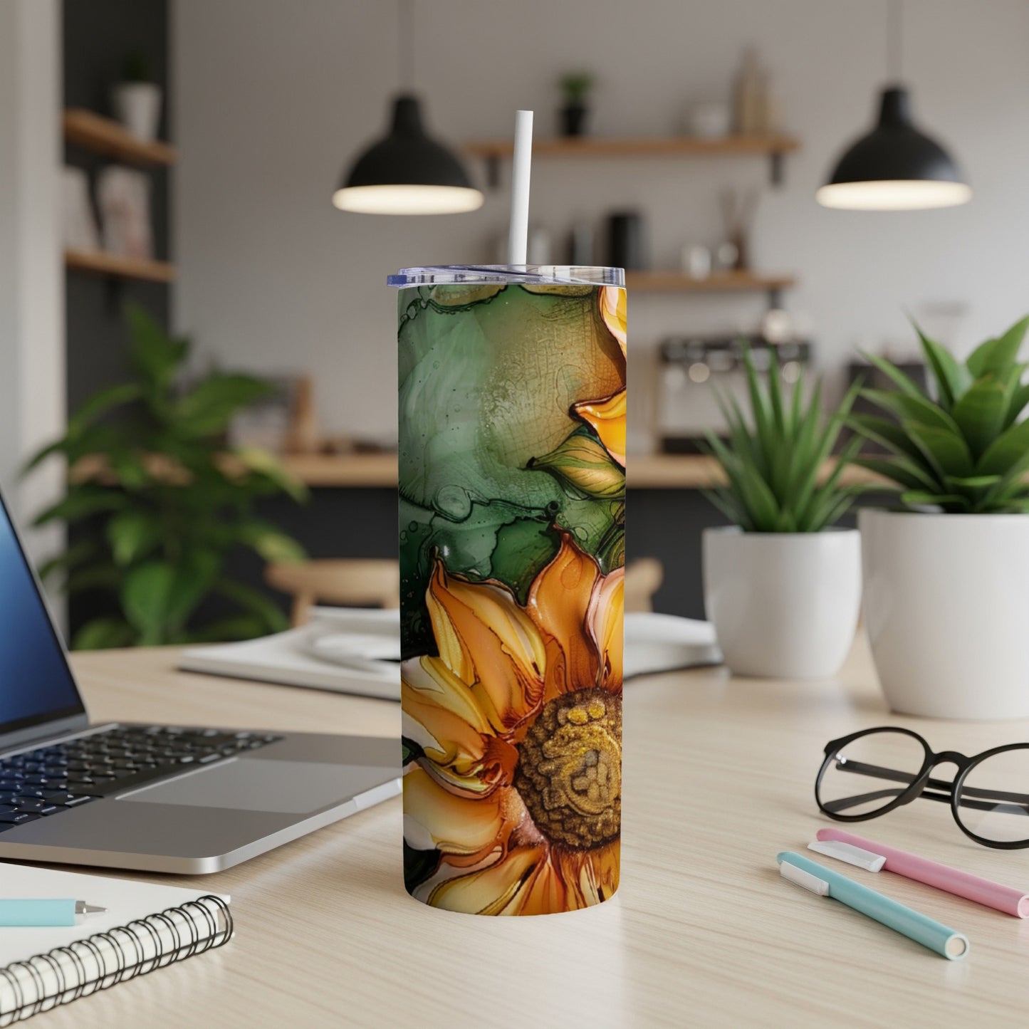 Tall tumbler with a vibrant sunflower design and white straw, on a desk.