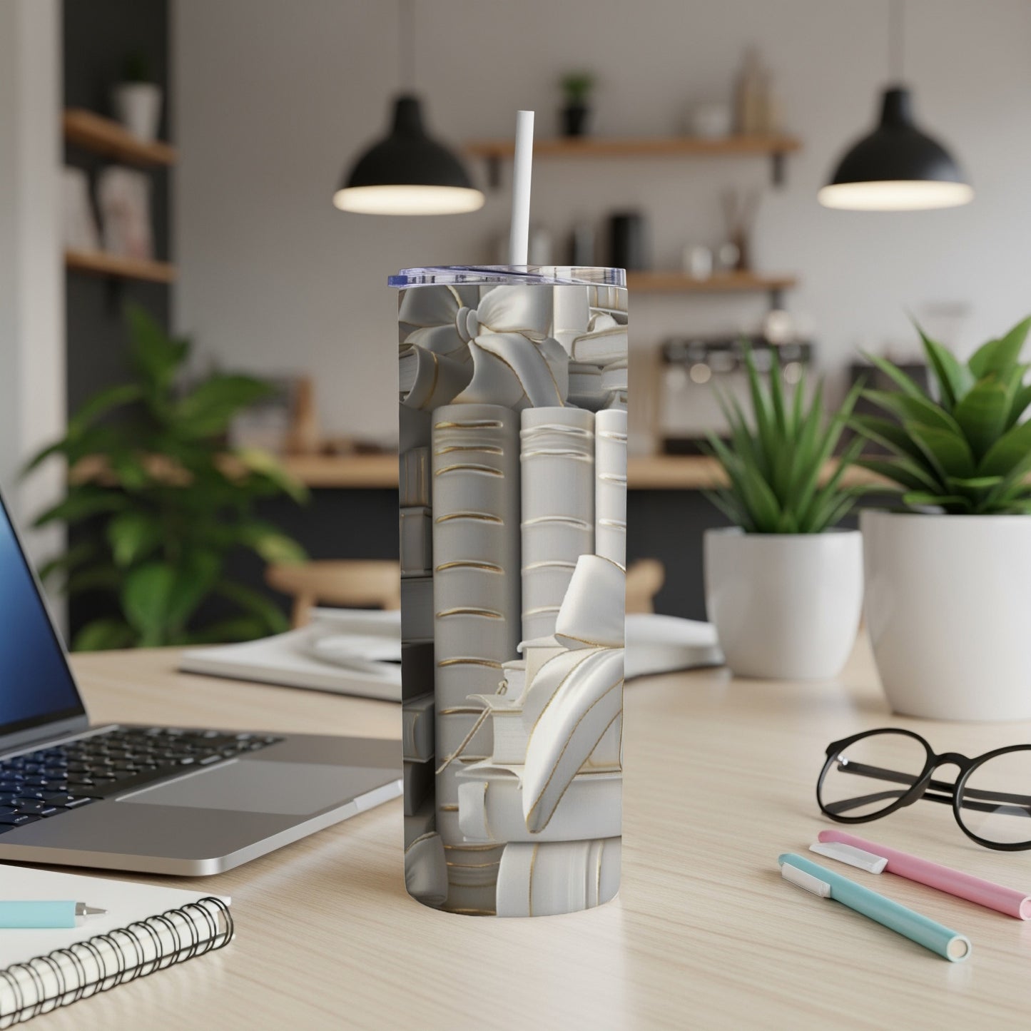 Stack of white and gold books with a straw on a desk.