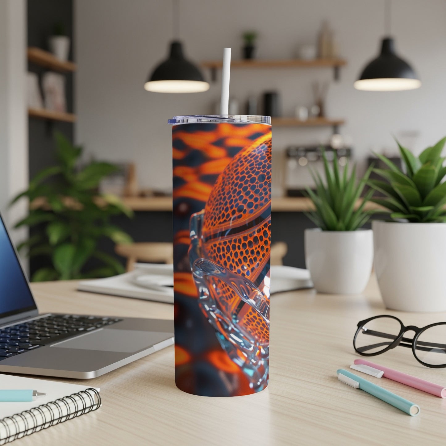 Close-up of an orange and black basketball pattern on a tumbler with a white straw.