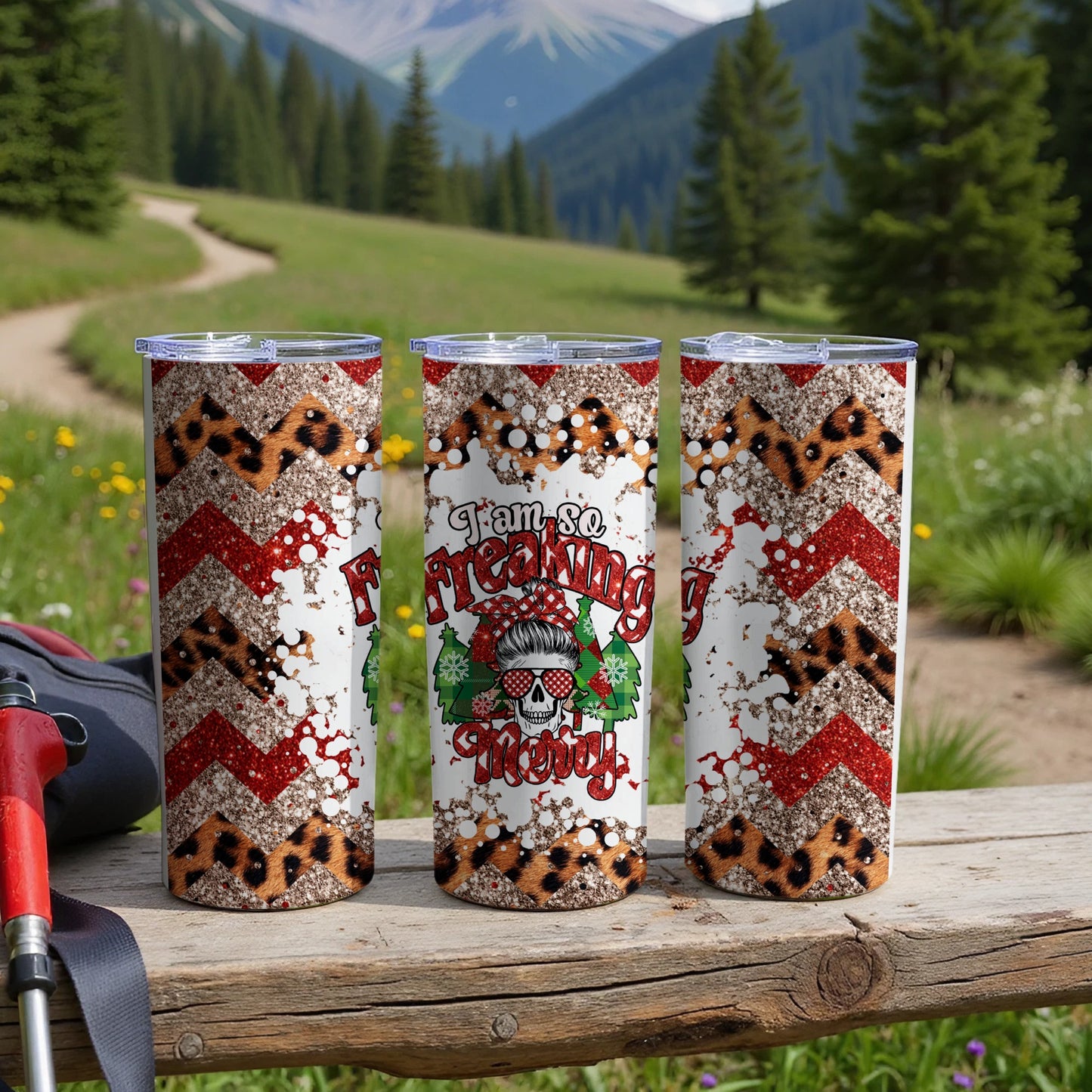 Three tumblers with a "I am so Freaking Merry" design on a wooden surface.