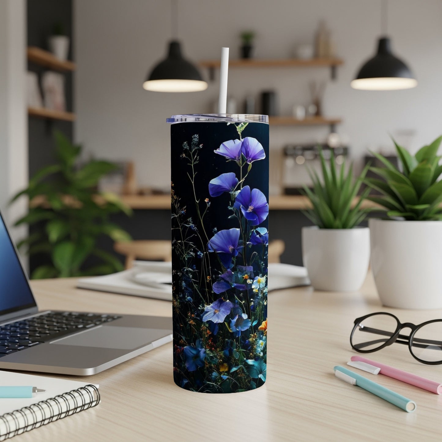 Blue wildflowers on a dark background adorn a tall, slim tumbler.