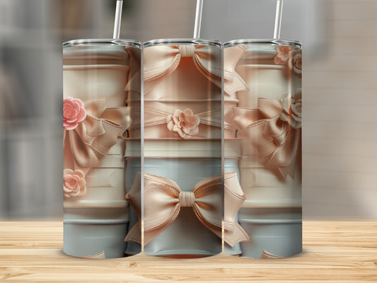 Three blush pink tumblers decorated with satin bows and floral accents.