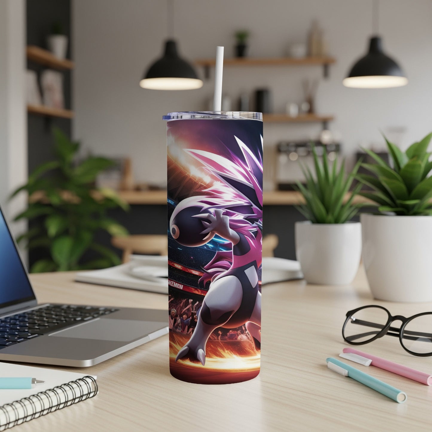 Pokemon tumbler with character artwork on a desk with a laptop and pens.