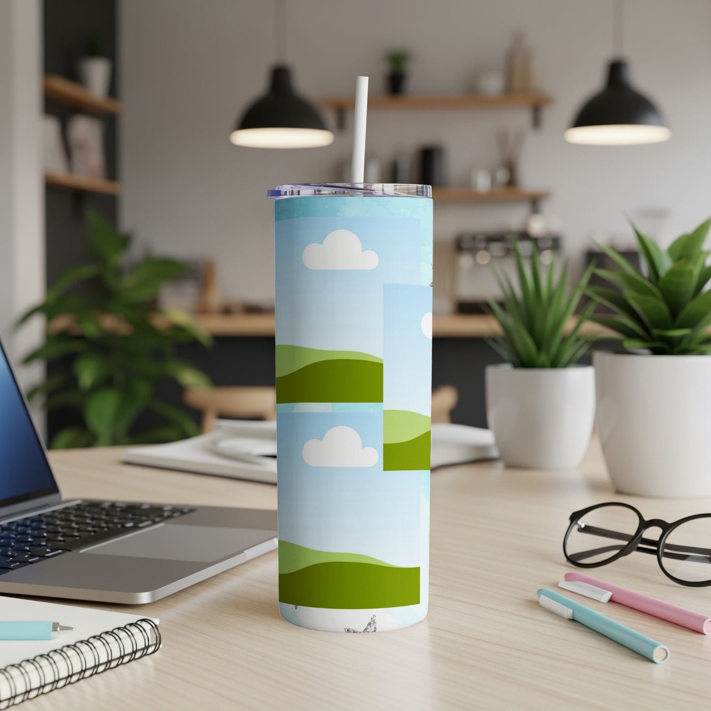 Tall tumbler with a green landscape and cloud pattern, featuring a straw.