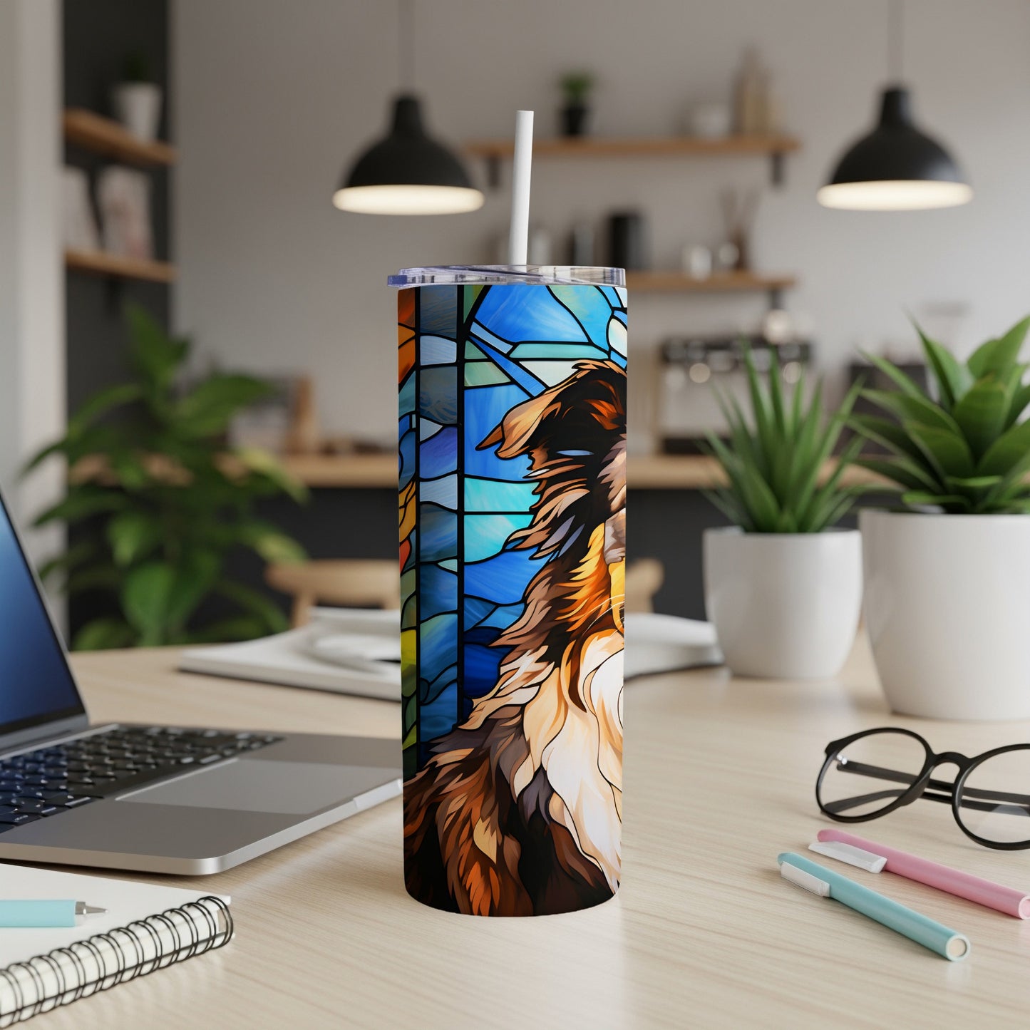 Stained glass dog tumbler with a straw on a desk.