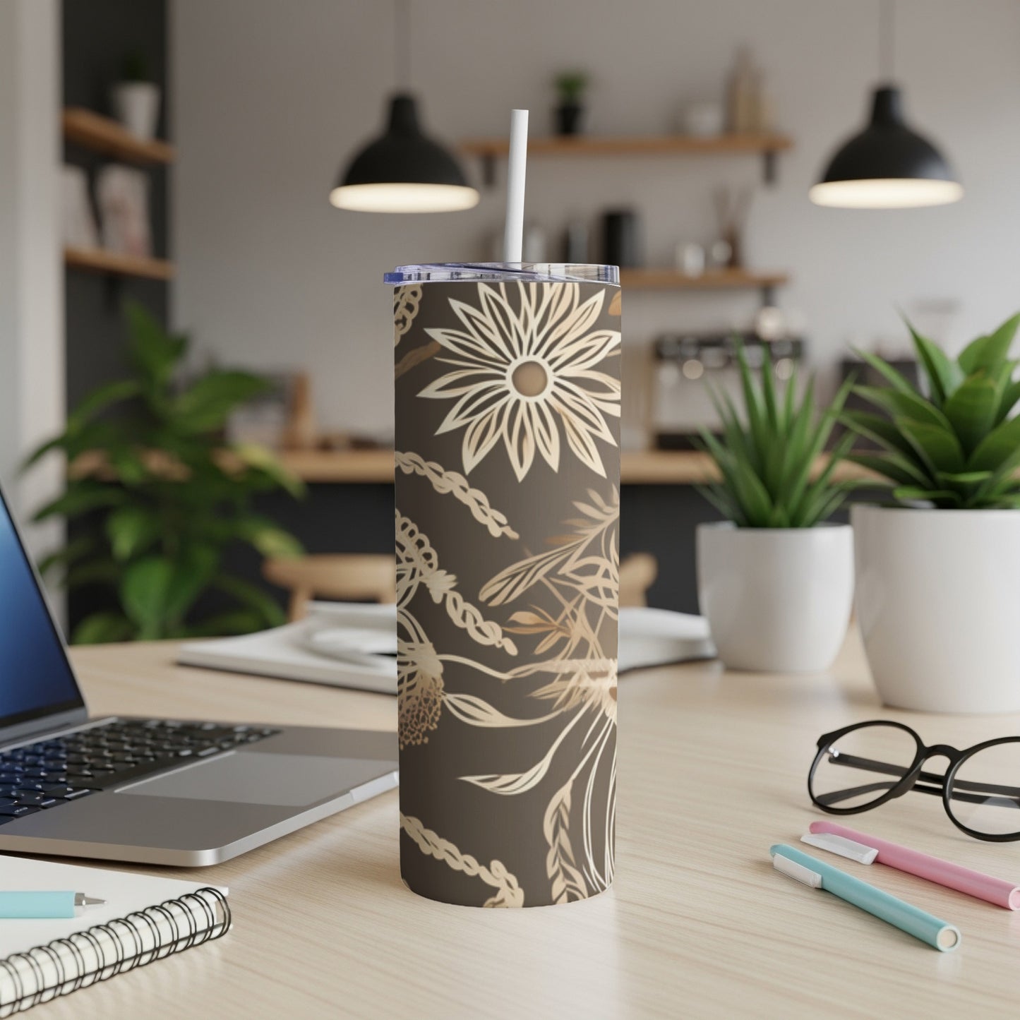 Brown tumbler with floral and chain pattern and white straw on desk.